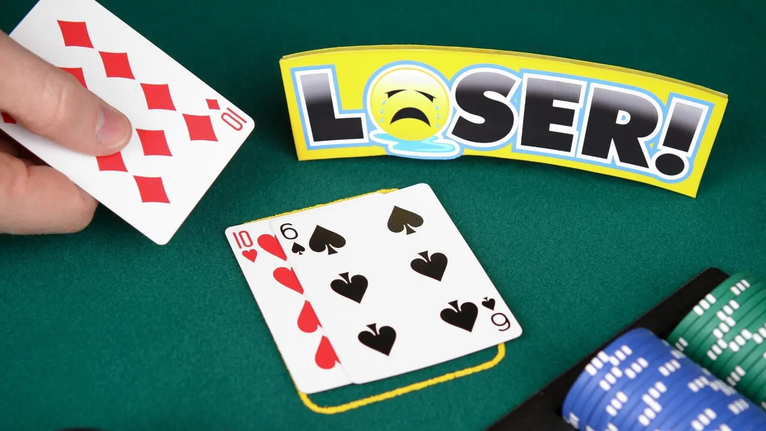 Poker hand where ten of diamonds loses to ten and six on green poker table with “Loser” sign.