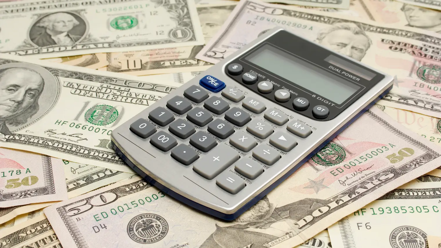 Calculator on US dollar bills. Calculate poker odds.
