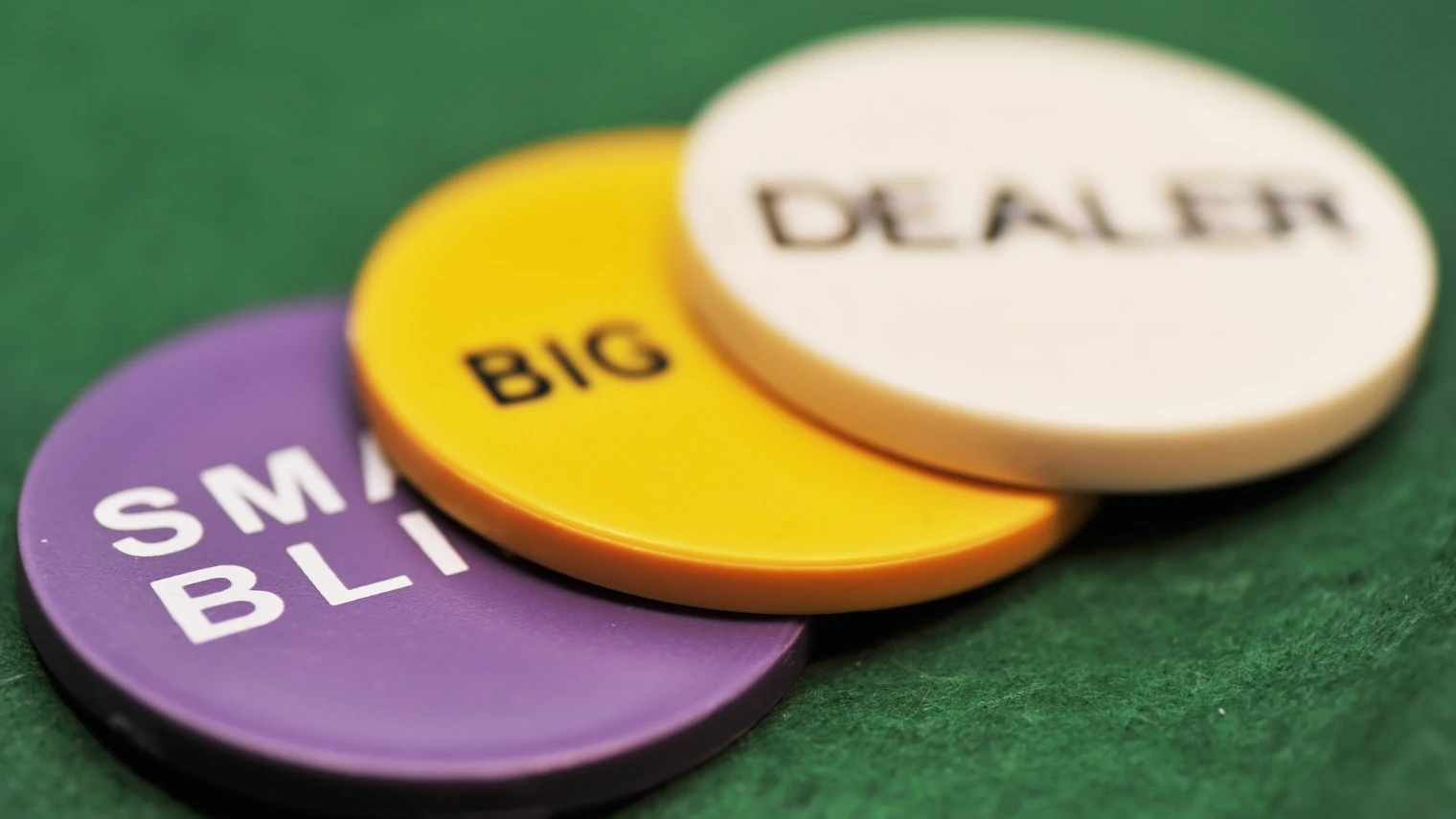 Poker chips labeled small blind, big blind and dealer.